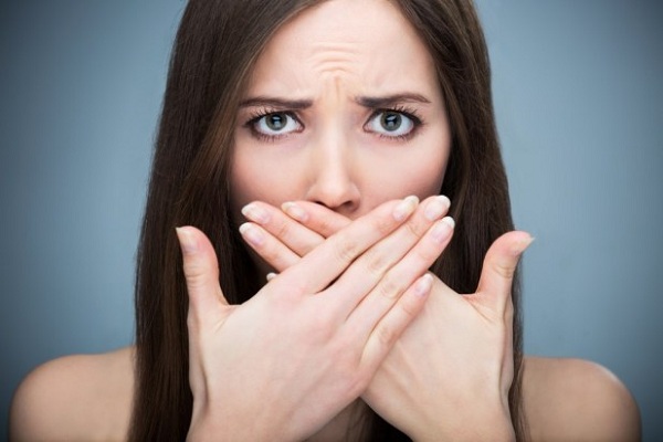 một phụ nữ lấy 2 tay che miệng